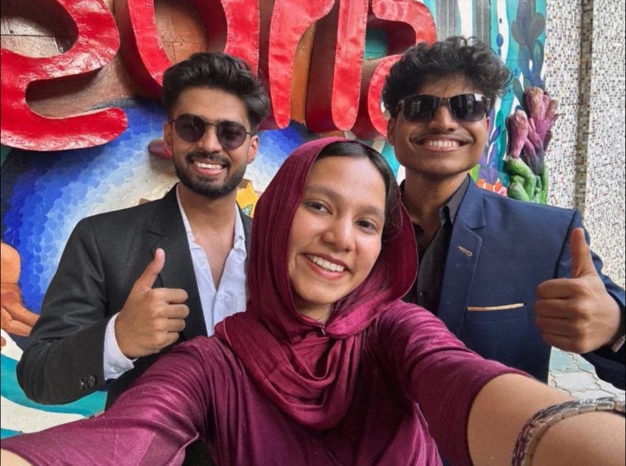 Group selfie in front of a colorful street-art mural, everyone smiling