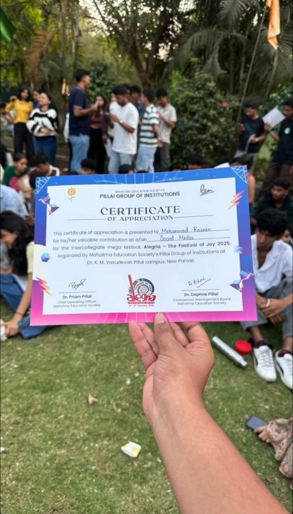 Hand holding up a certificate outdoors on grass